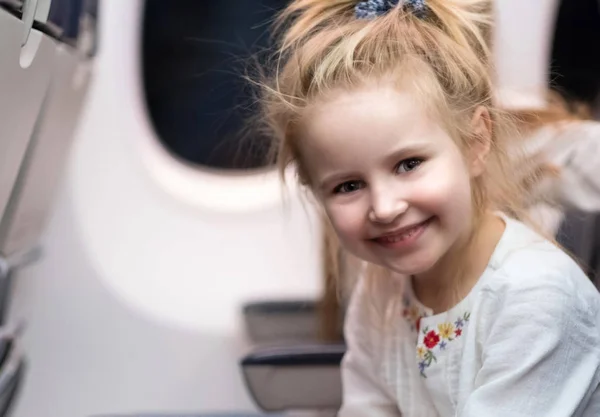 Jong meisje glimlachend op het bord van vliegtuigen — Stockfoto