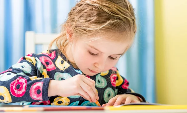 Küçük sarışın kız kalemle resim çiziyor. — Stok fotoğraf