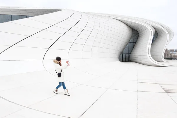 Vrouw maakt een foto in de buurt van Heydər Aliev Center — Stockfoto