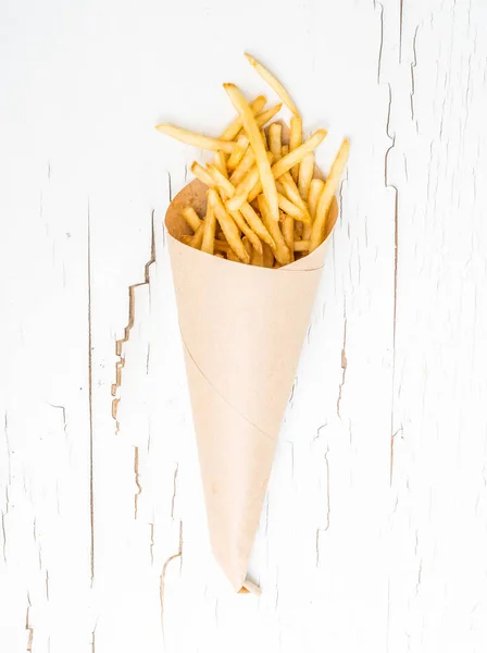 Batatas fritas embrulhadas em papel sobre fundo branco — Fotografia de Stock
