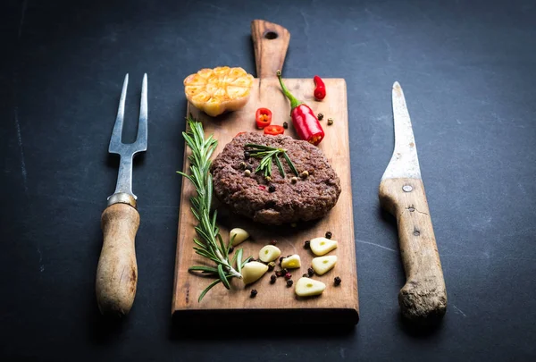 Frisches hausgemachtes Rindfleisch-Burger-Schnitzel auf Kochbrett — Stockfoto