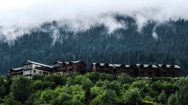 Утренний туман над деревянными коттеджами в горах — стоковое видео