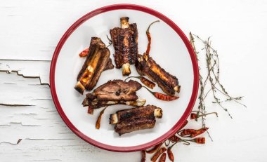 Domuz kaburga beyaz tabakta, üstten görünüm.