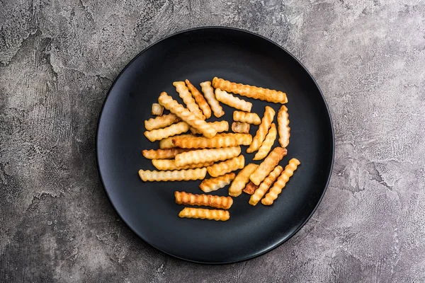 Patate francesi su piatto scuro, vista dall'alto — Foto Stock