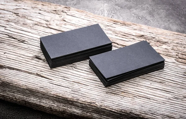 Stapels zwarte lege visitekaartjes op houten achtergrond — Stockfoto