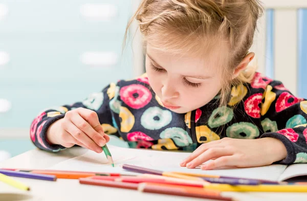 Маленькая блондинка рисует карандашами. — стоковое фото