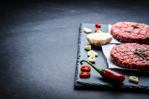 Costeletas de hambúrguer de carne crua com ingredientes — Fotografia de Stock