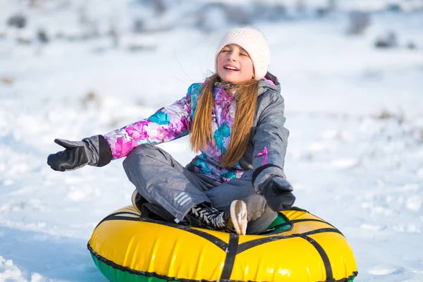 Little girl sitting on tubing snow — Stock Photo, Image