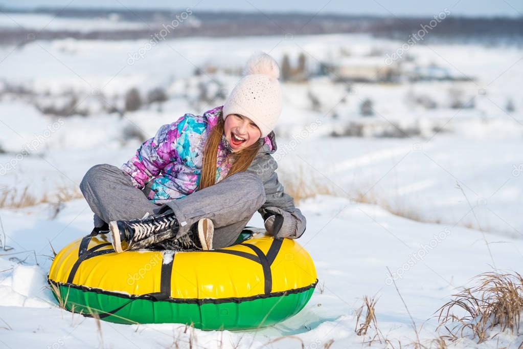Girl laughinh while snow tubing