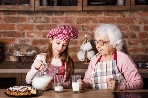 Babička s vnučkou konzumní mléko — Stock fotografie
