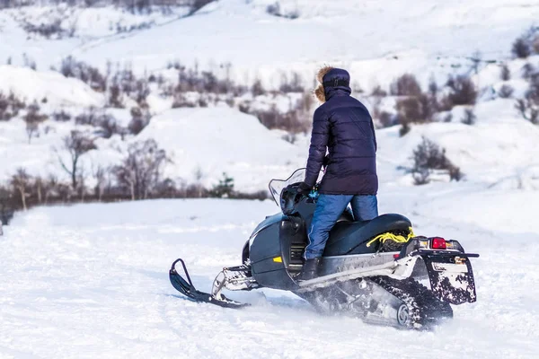 Человек едет на снегоходе по заснеженным полям — стоковое фото