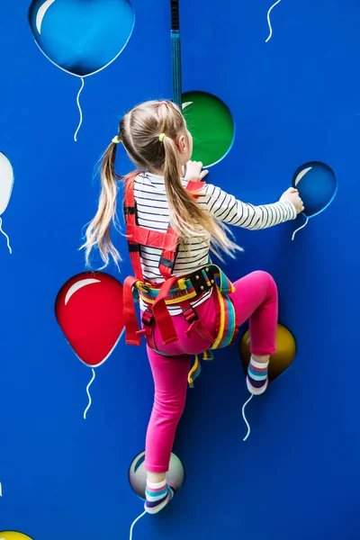 Pequena menina desportiva na parede de escalada — Fotografia de Stock