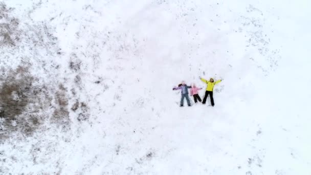 Мама и дочери лежат на снегу — стоковое видео