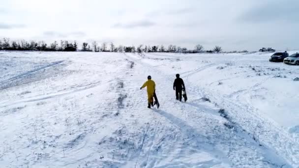 Snowboarders subiendo la pendiente para montar — Vídeos de Stock