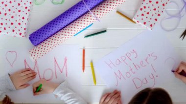 Küçük kız tebrik kartı çiziyor.