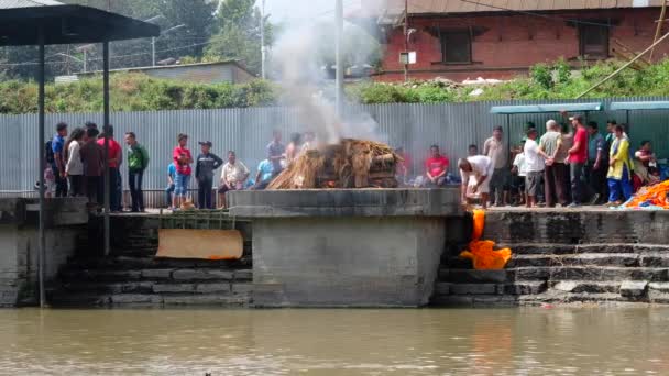 Непальцы усиливают огонь в крематории в Пашупатинатхе — стоковое видео