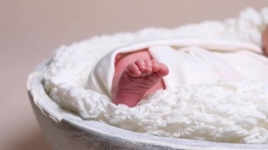 Yeni doğan bebek beyaz battaniye içinde çıplak ayak