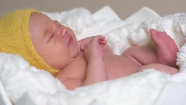 Νεογέννητο παιδί σε κίτρινο καπέλο στον ύπνο — Αρχείο Βίντεο