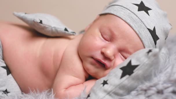 Neugeborener Junge im grauen Pyjama — Stockvideo