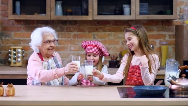 Systrar med mormor sitter vid bord — Stockvideo