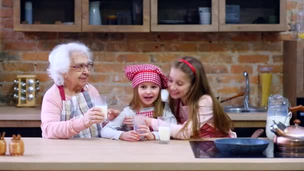 Сестры с бабушкой сидят за столом — стоковое видео