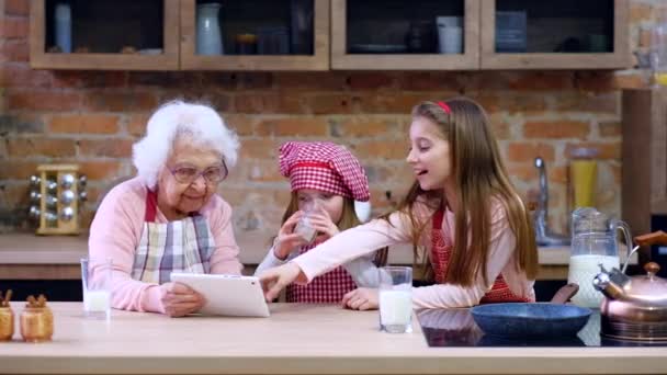 Внучка и бабушка с табличкой на кухне — стоковое видео