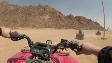 Çölde dörtlü bisiklet sürüyor.