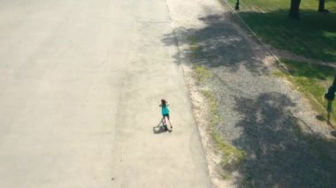 Küçük kız scooter 'a biniyor