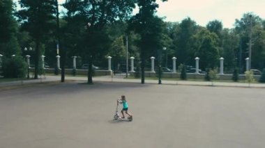 Küçük kız scooter 'a biniyor