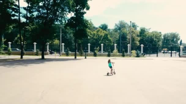 Pequena menina passeio em scooter pontapé — Vídeo de Stock