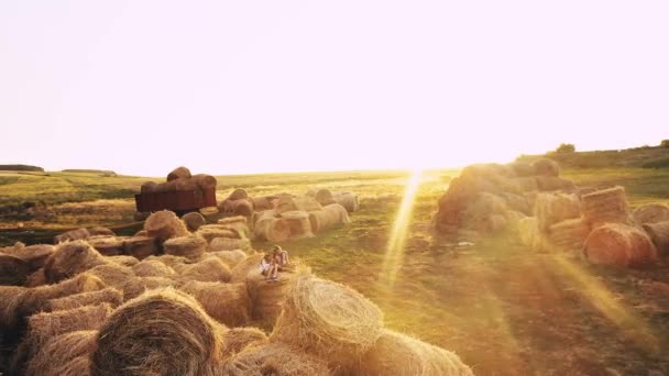 Two kid girls on haystacks in summer field — Stock Video