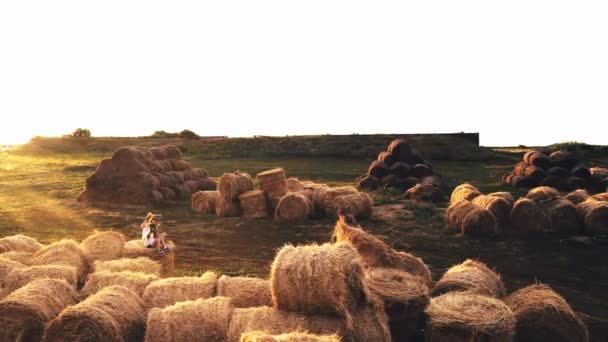 Two kid girls on haystacks in summer field — Stock Video