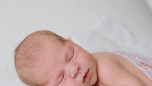 Niño recién nacido en sábanas blancas — Vídeo de stock
