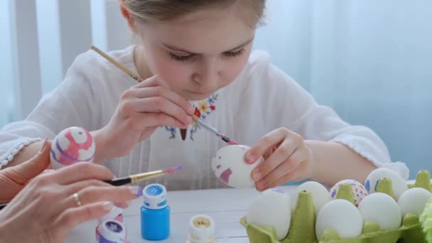 Pre-teen girl is coloring eggs — Stock Video