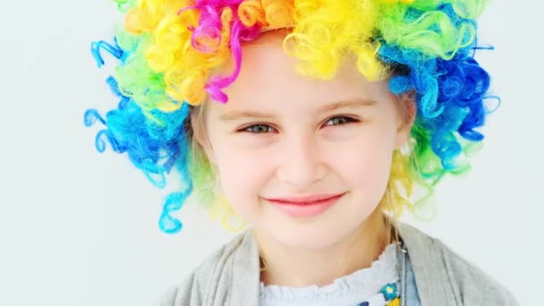 Linda menina sorridente em peruca arco-íris — Vídeo de Stock