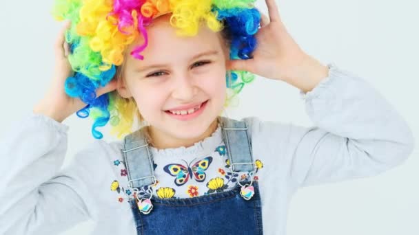 Niño en peluca colorida con las manos arriba — Vídeos de Stock