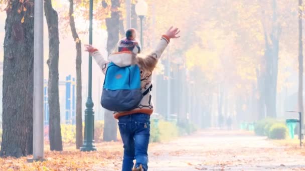Child going across autumn park — 비디오