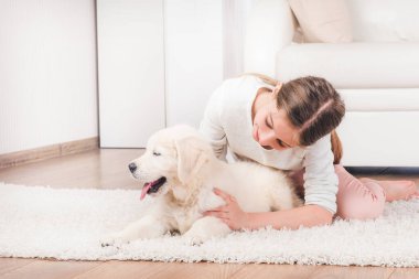 Sevimli kabarık retriever köpek yavrusu sarılma ile yalan Kız