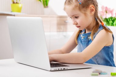 Küçük kız laptopunu kullanıyor.
