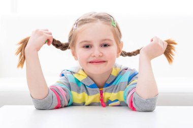 Onu örgülü pigtail saç kesimi ile oynayan okul çağındaki kız