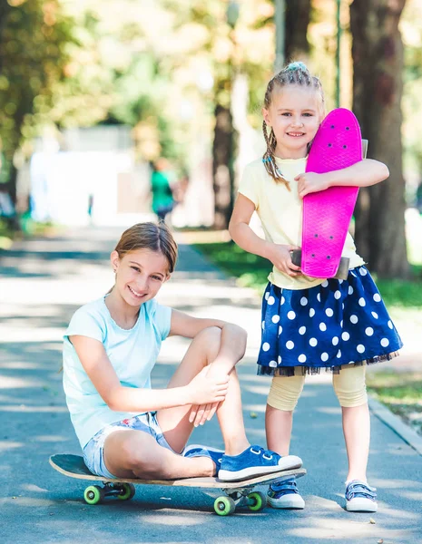 Leende flickor med skateboards — Stockfoto