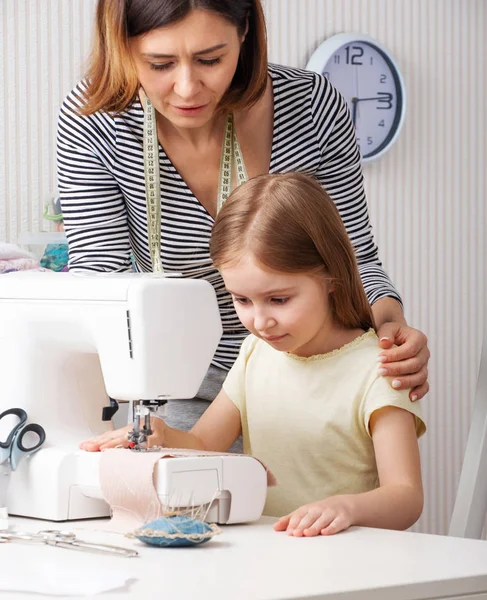 Donna che mostra al bambino come cucire a casa — Foto Stock