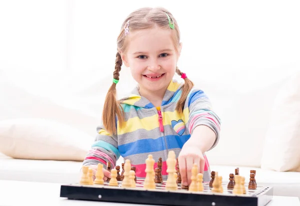 Улыбающаяся девочка играет в шахматы — стоковое фото