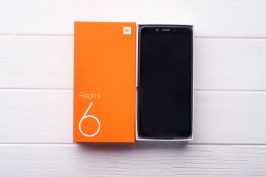 Yeni Xiaomi Redmi 6 akıllı telefon ahşap bir masada.