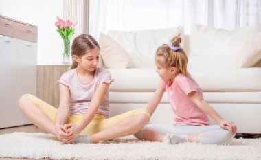 Kızlar evde meditasyon yapıyor.