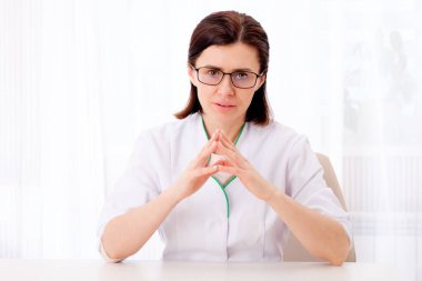 Masada oturan kadın çocuk doktoru.