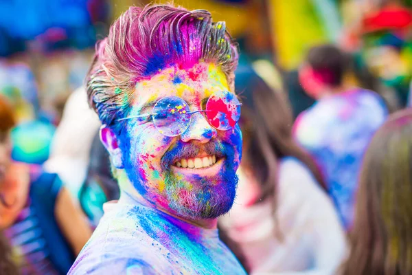 Holi toz yüzünde gözlüklü genç adam