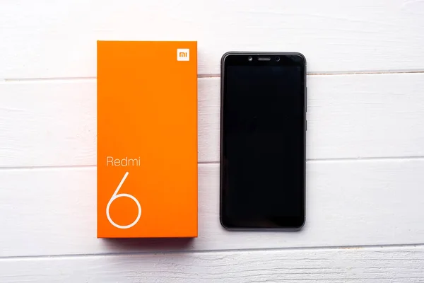 Nowy smartfon Xiaomi Redmi 6 na drewnianym stole — Zdjęcie stockowe