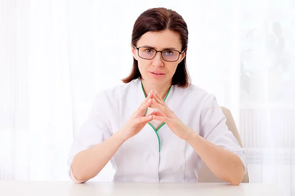 Женщина-педиатр сидит за столом — стоковое фото