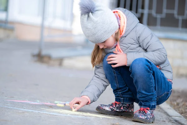 Kleines Mädchen zeichnet auf Asphalt — Stockfoto